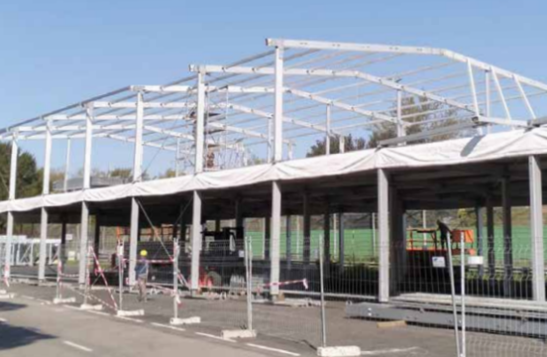 Tendostrutture in due piano in costruzione, si vedono gli operai e le gru