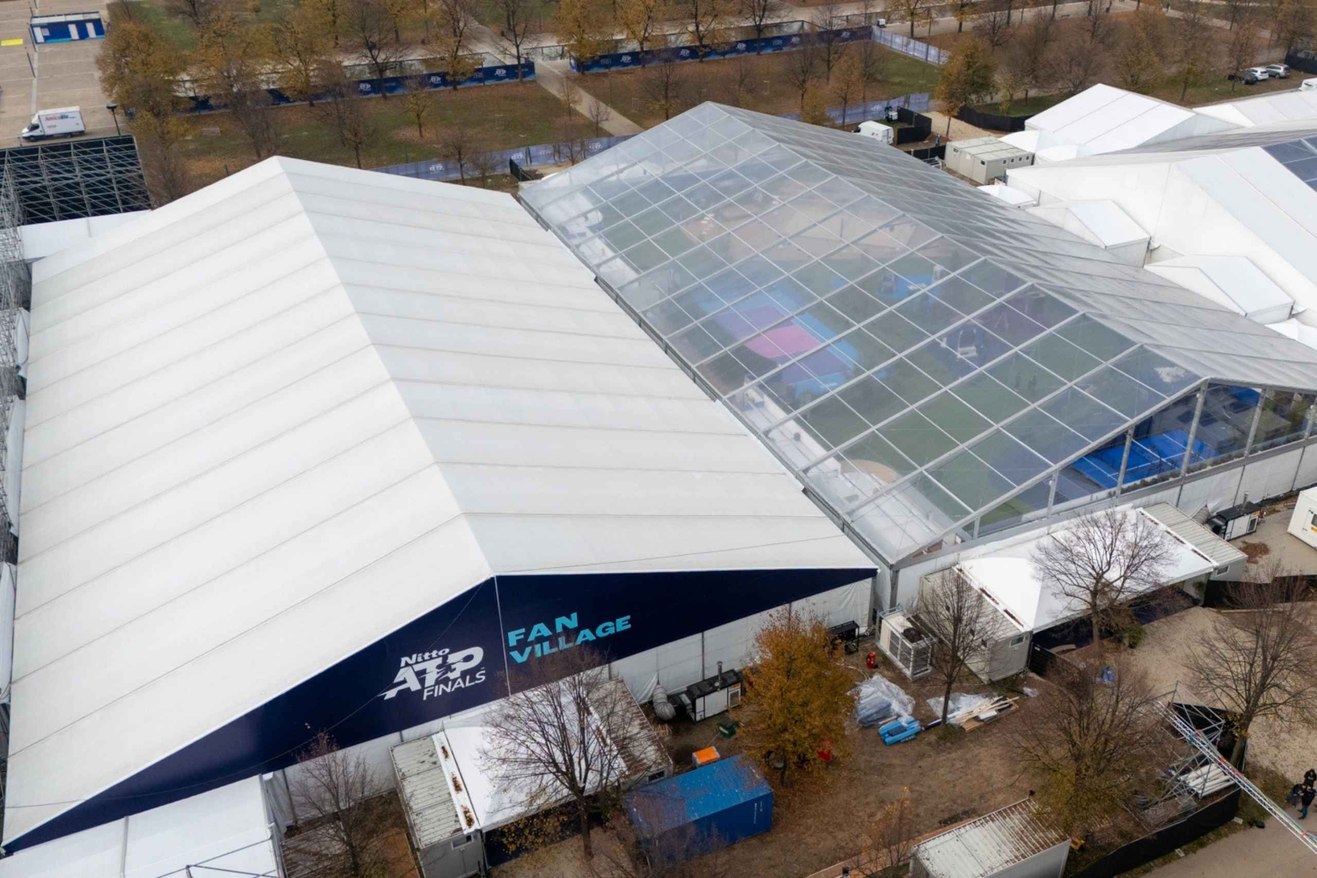 Foto ravvicinata dall'alta di due tendostrutture bianche, una con il logo degli ATP ben visibile su sfondo blu