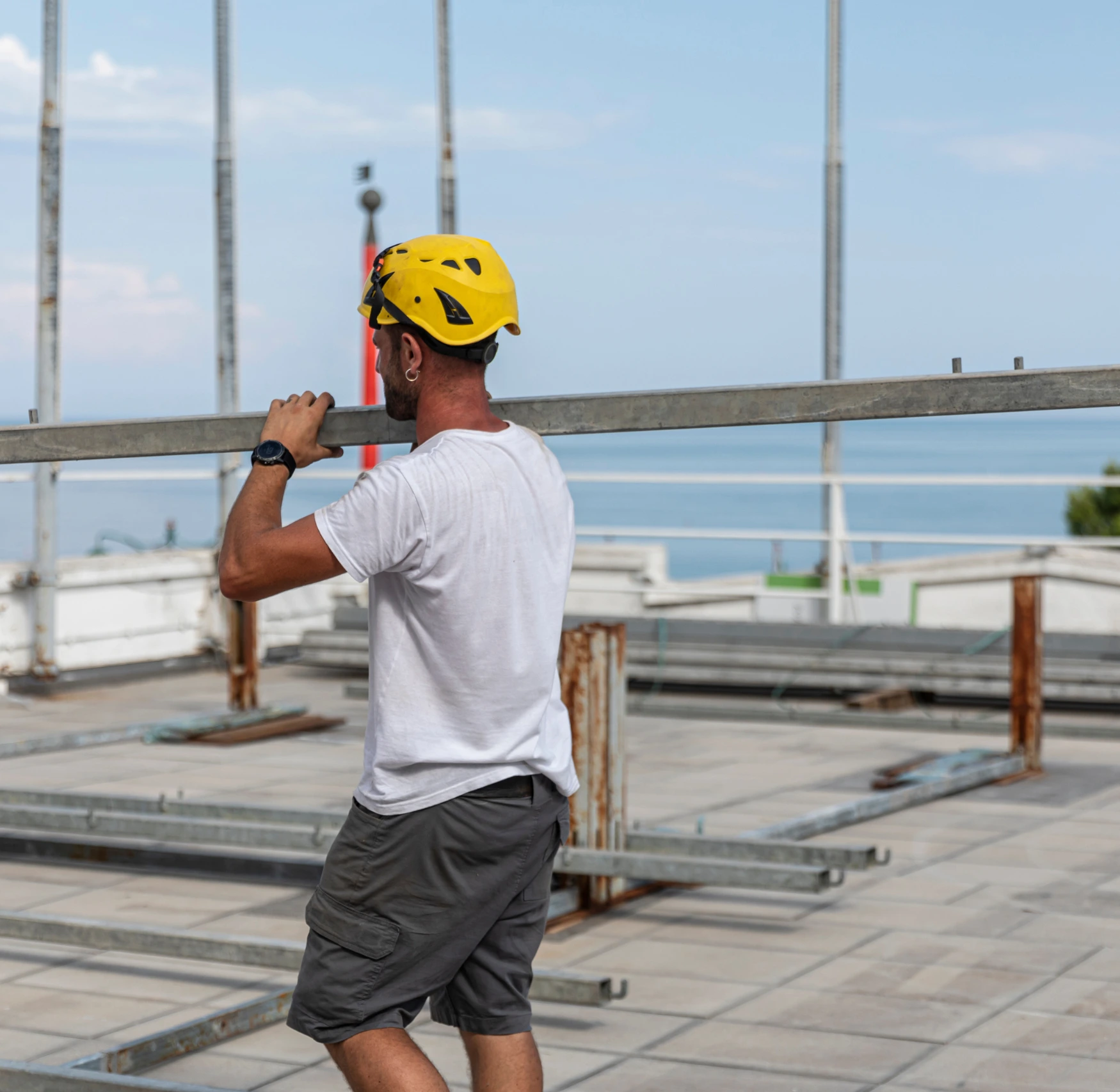 lavoratore eurotend al lavoro che trasporta una trave di una tendostruttura